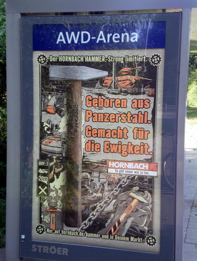 Bushaltestelle des Niedersachsenstadions, das jetzt AWD-Arena heißt und somit selbst zur Reklame geworden ist, mit einer Reklame für Hornbach: Geboren aus Panzerstahl, gemacht für die Ewigkeit
