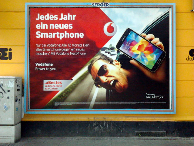 Vodafone-Werbeplakat. Jedes Jahr ein neues Smartphone -- Nur bei Vodafone: Alle 12 Monate Dein altes Smartphone gegen ein neues tauschen. Mit Vodafone NextPhone -- Vodafone. Power to You.