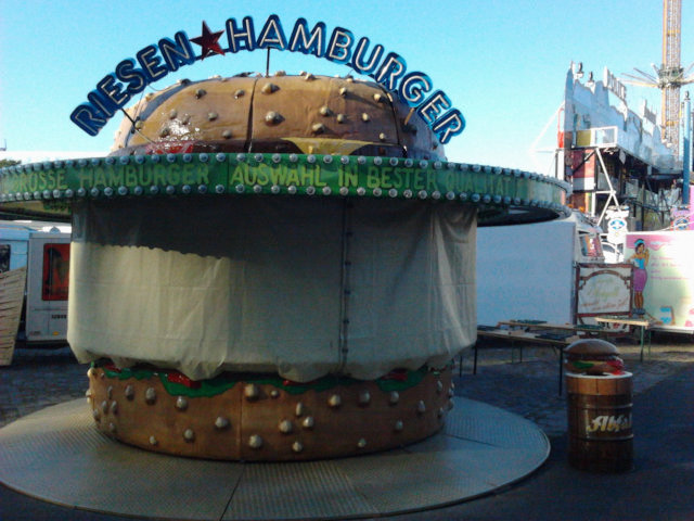 Bereits fertig aufgebauter Verkaufsstand für das morgen beginnende hannöversche Schützenfest: Riesen Hamburger. Der Verkaufsstand hat selbst die Form eines Hamburgers. Daneben steht die Mülltonne.